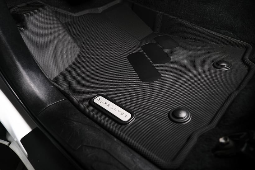 the interior of a car with black floor mats