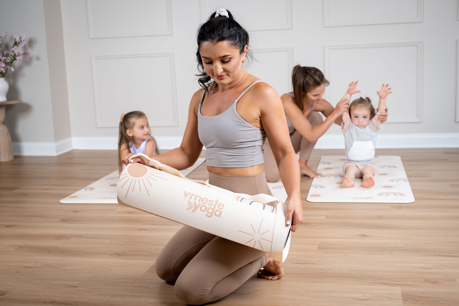 a person is sitting on a yoga mat with their children